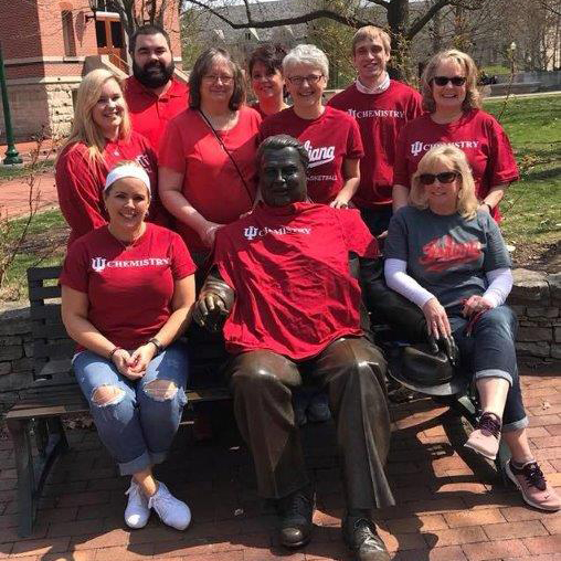 Judi Roberts and co-workers posing with statue